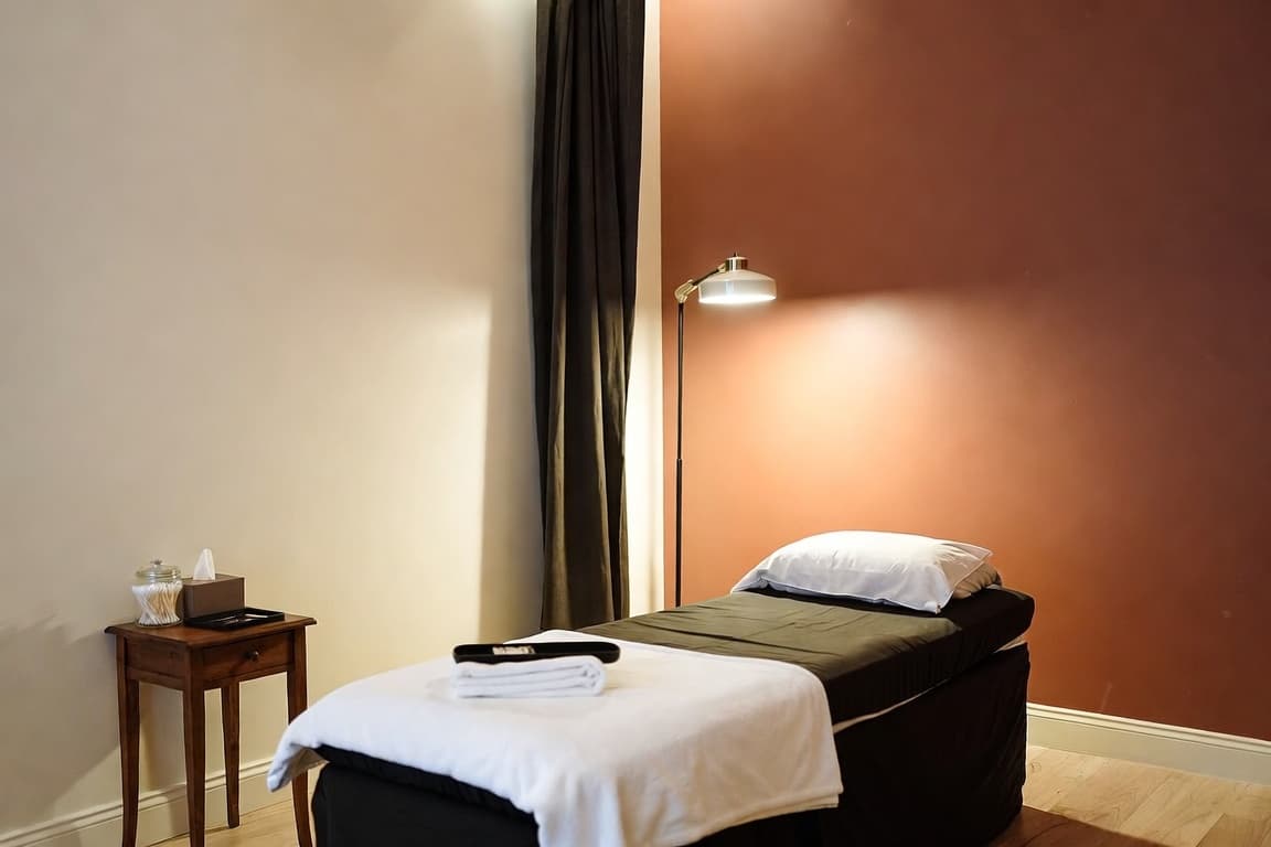 A calm, softly lit lash studio with a treatment bed prepared for a client